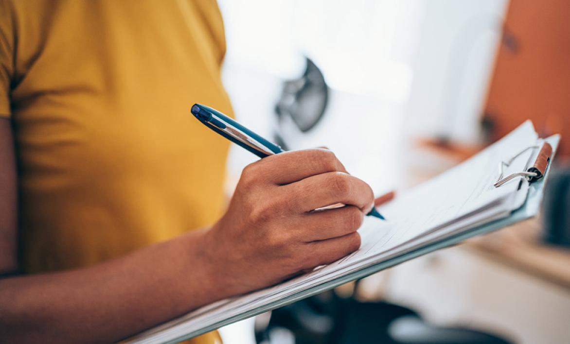 Personne procédant à un sondage en prenant des notes.