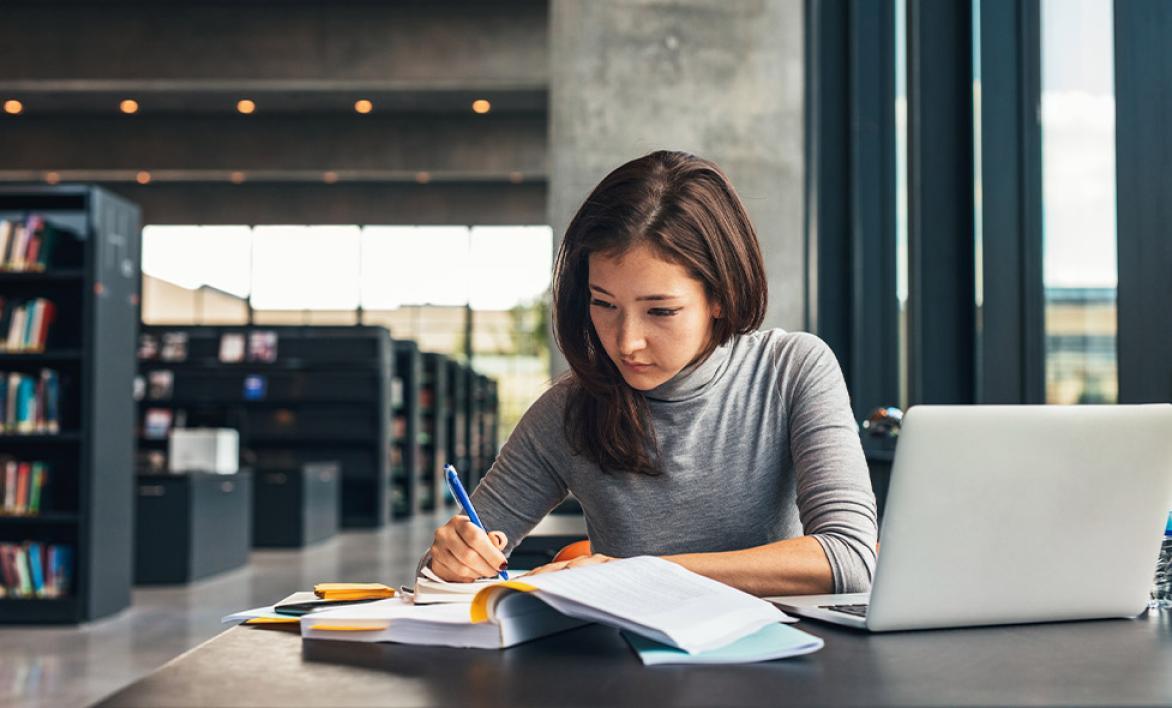 Jeune femme étudiant à la bibliothèque.