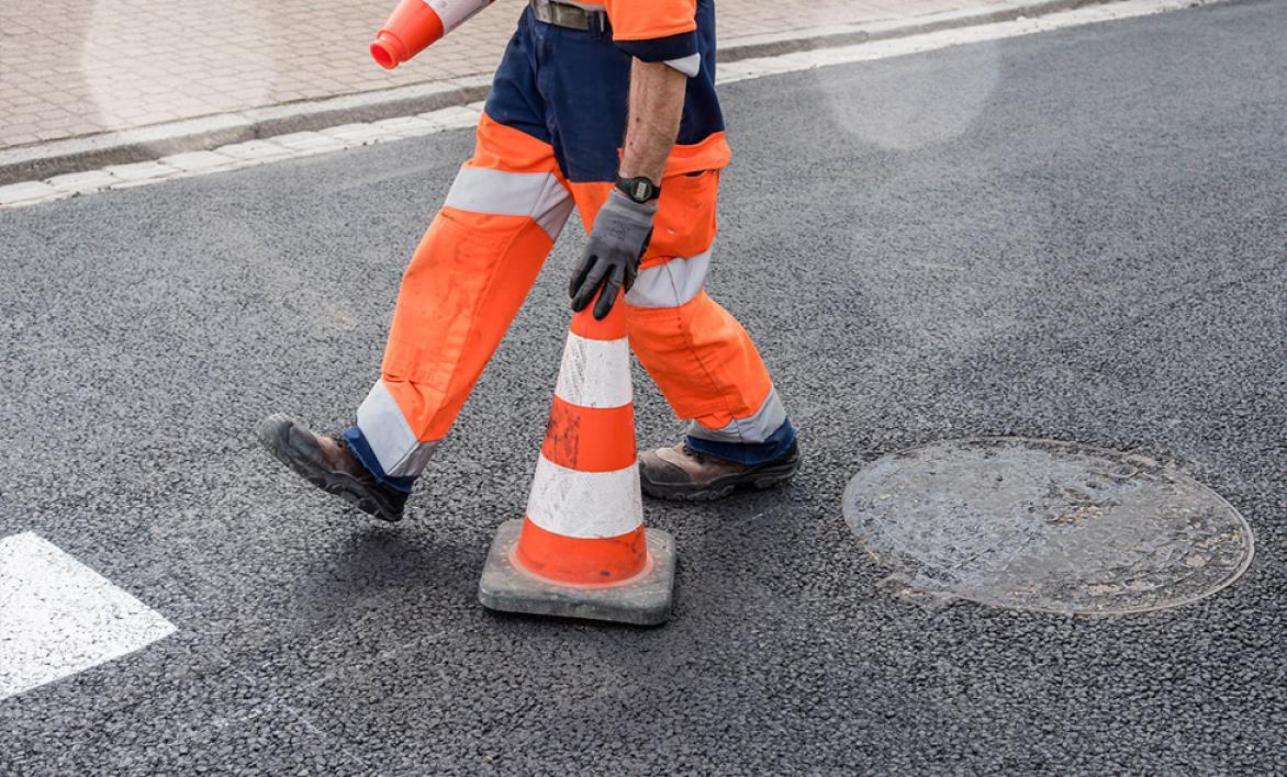 Employé routier qui installe un plot de chantier.