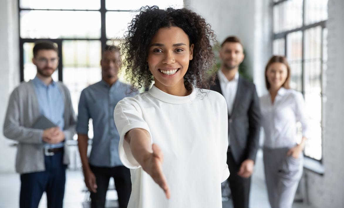Une jeune femme tendant la main avec un groupe en arrière plan.