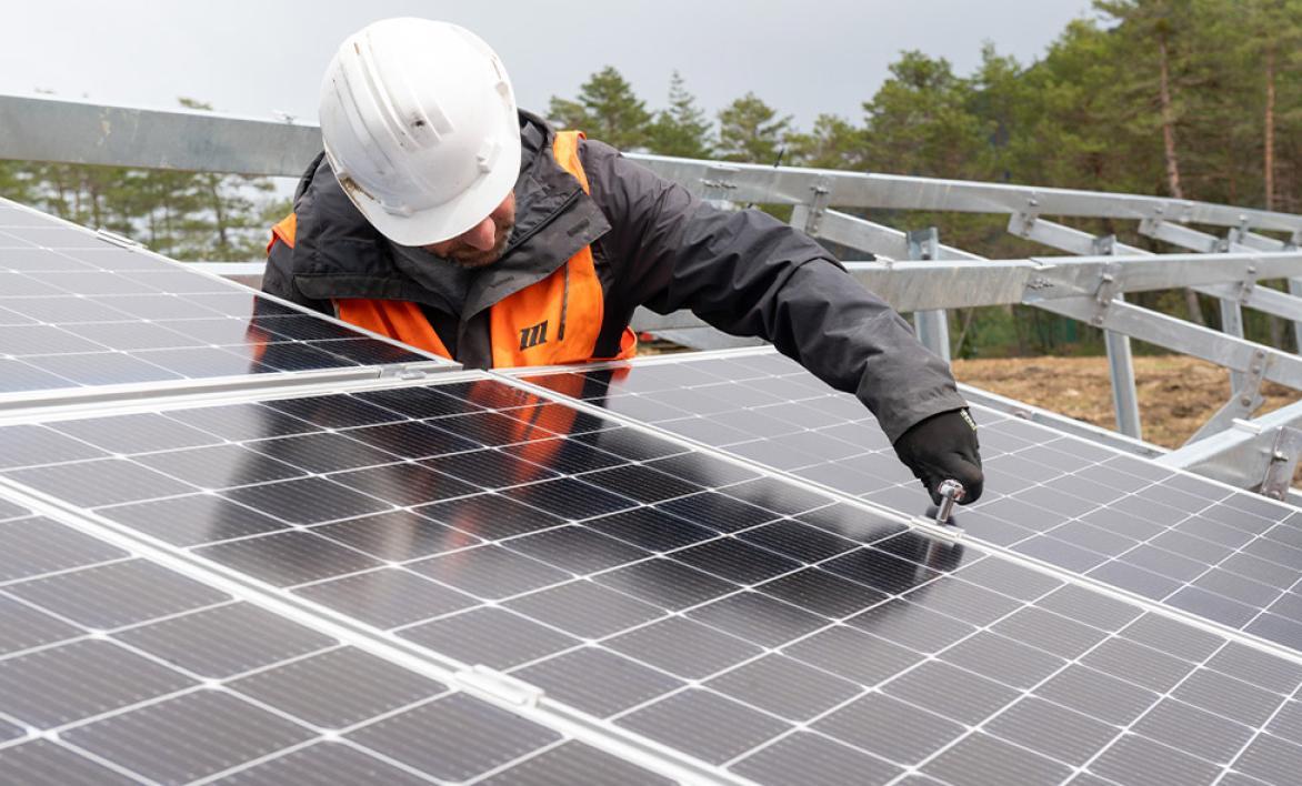 Un homme installant un panneau photovoltaïque.