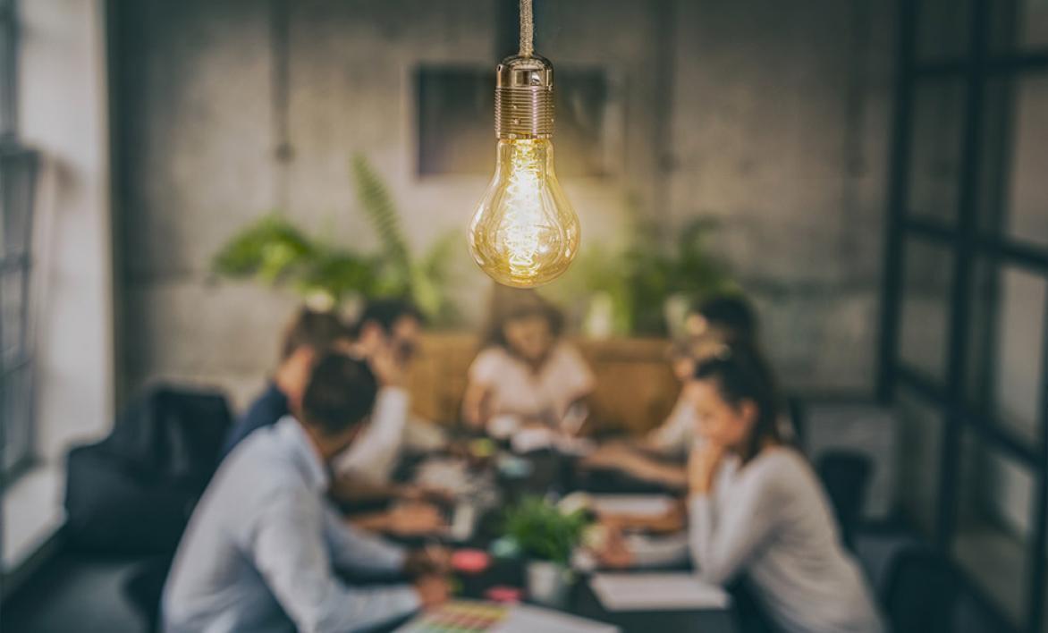Ampoule lumineuse avec des personnes discutant autour d'une table.