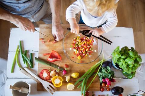 Un adulte et un enfant qui cuisine.