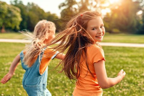 Deux enfants courant sur une pelouse.