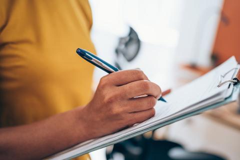 Personne procédant à un sondage en prenant des notes.