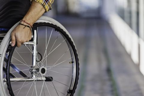 Un fauteuil roulant avec une main.