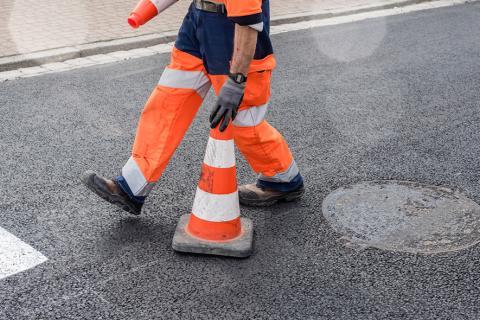 Employé routier qui installe un plot de chantier.