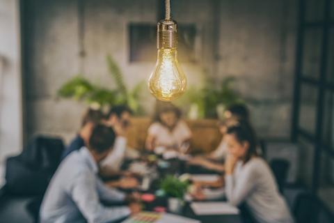Ampoule lumineuse avec des personnes discutant autour d'une table.